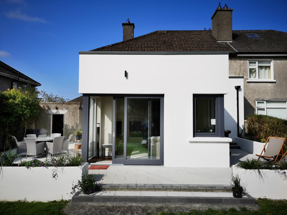 Design ideas for a contemporary two-storey stucco white duplex exterior in Other with a flat roof.