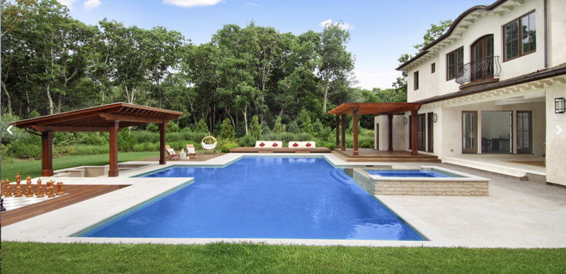 Large backyard stone and rectangular lap hot tub photo in New York