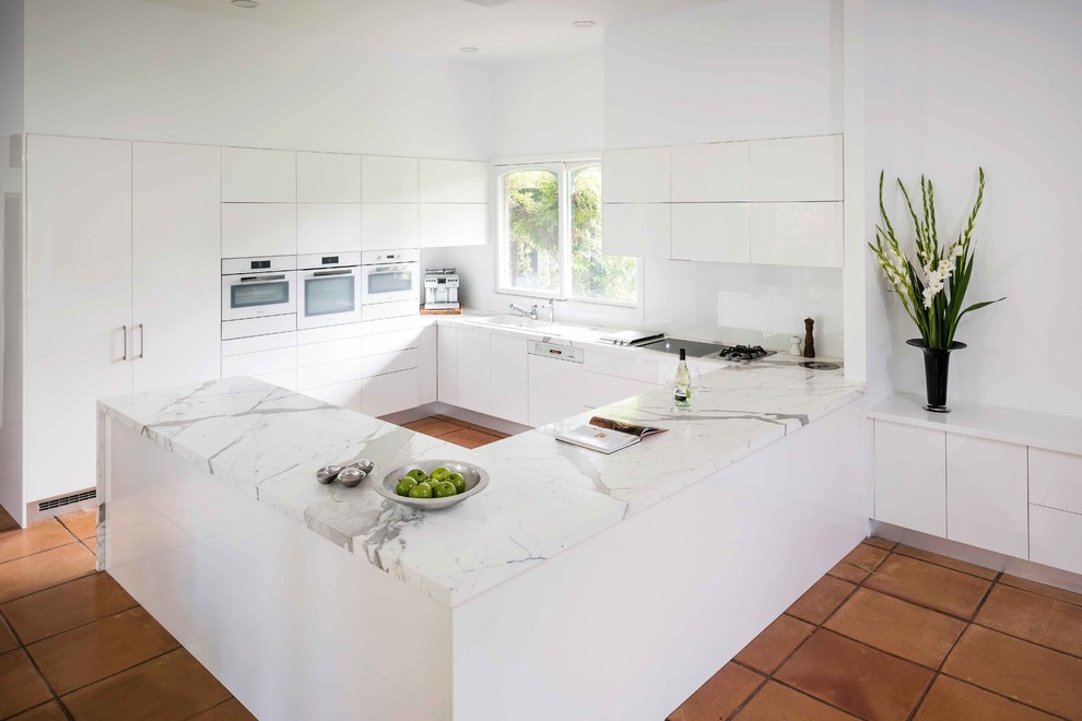 Photo of a mid-sized modern u-shaped kitchen in Melbourne with with island and porcelain floors.
