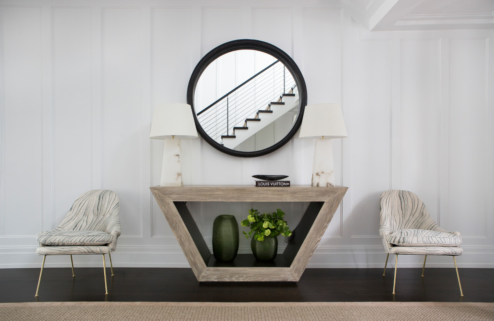 Photo of a transitional foyer in New York with white walls and dark hardwood floors.