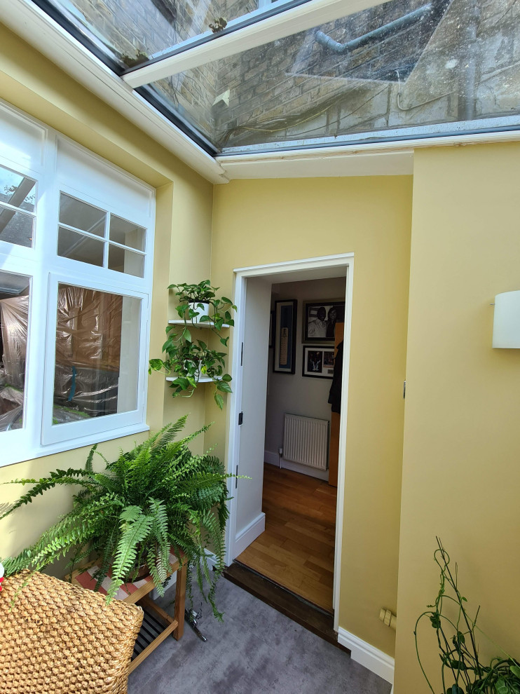 Idée de décoration pour un porche d'entrée de maison arrière tradition de taille moyenne avec une moustiquaire, du carrelage, une extension de toiture et un garde-corps en verre.