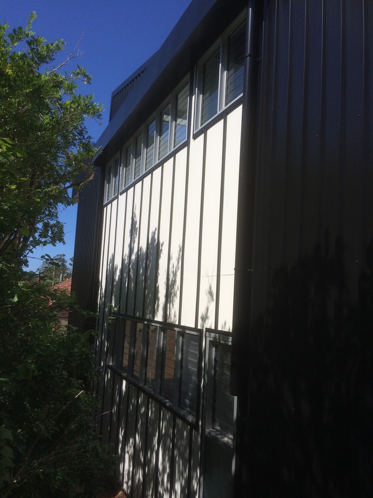 This is an example of a large industrial two-storey black exterior in Other with metal siding and a shed roof.