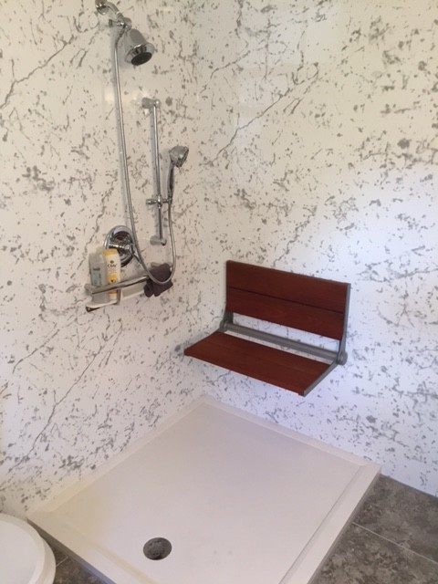 This is an example of a small contemporary 3/4 bathroom in Boston with an open shower, white walls and vinyl floors.