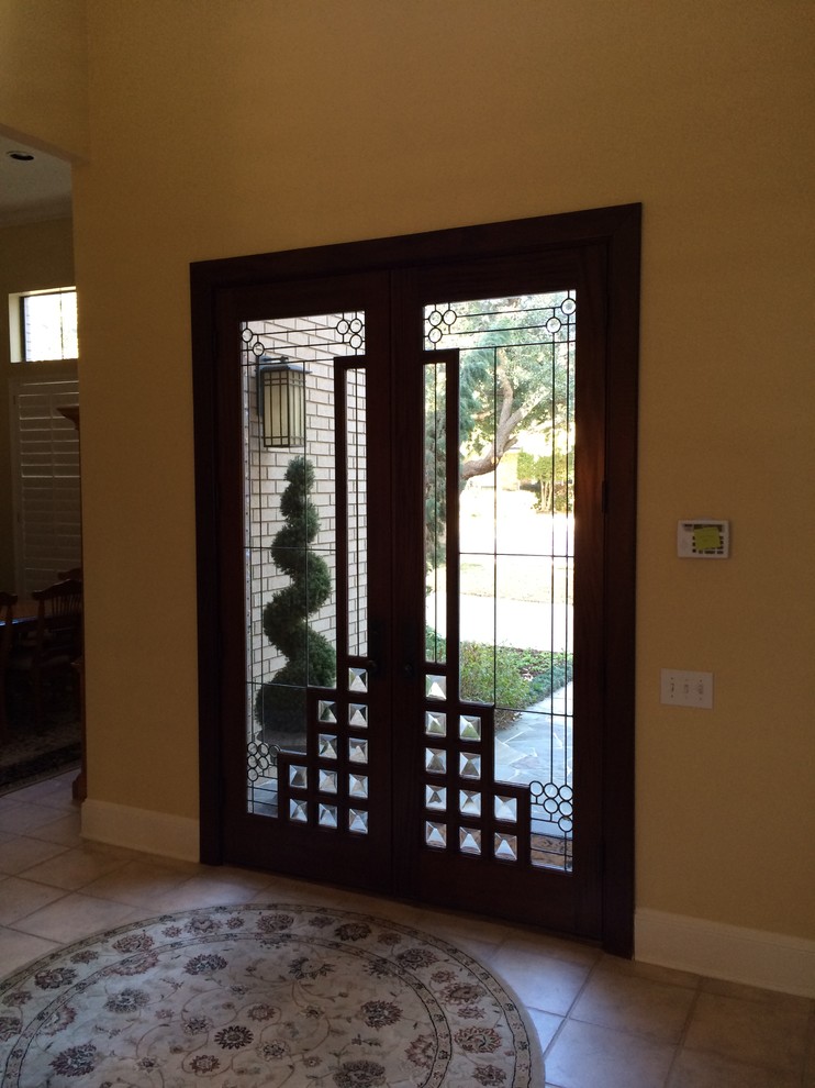 Example of a mid-sized transitional foyer design in Dallas with yellow walls and a dark wood front door