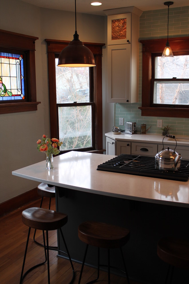 Inspiration for a mid-sized transitional medium tone wood floor kitchen remodel with an undermount sink, shaker cabinets, white cabinets, quartz countertops, blue backsplash, subway tile backsplash and an island