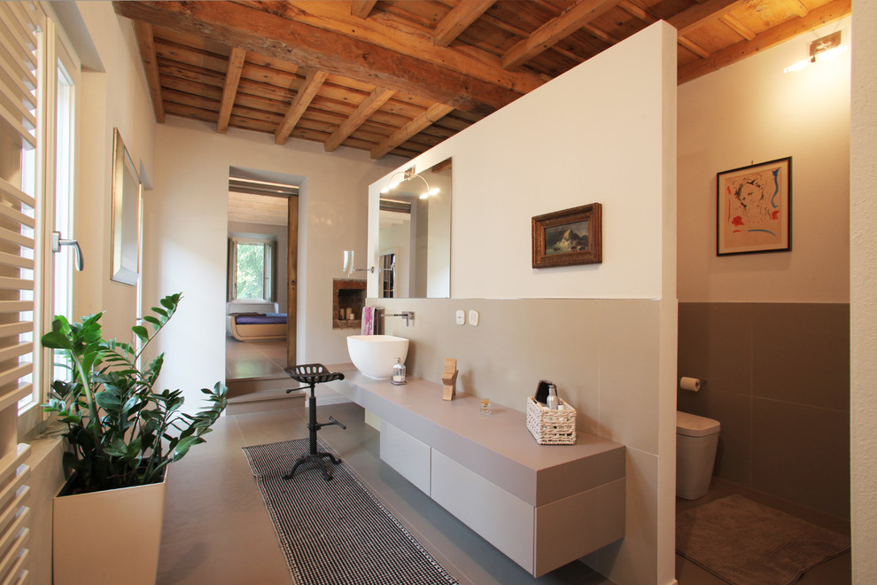 This is an example of a contemporary master bathroom in Milan with a vessel sink, flat-panel cabinets, beige cabinets and white walls.