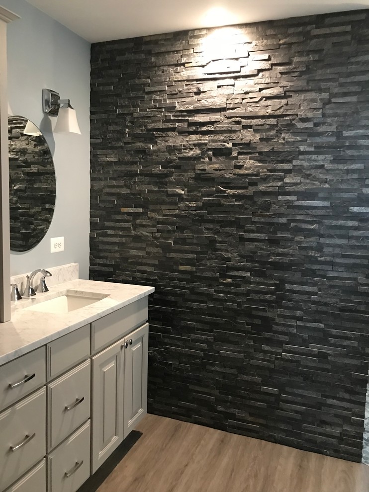Inspiration for a large contemporary master wet room bathroom in Richmond with raised-panel cabinets, grey cabinets, an undermount tub, a two-piece toilet, black and white tile, stone tile, blue walls, laminate floors, an undermount sink, quartzite benchtops, beige floor, an open shower and white benchtops.