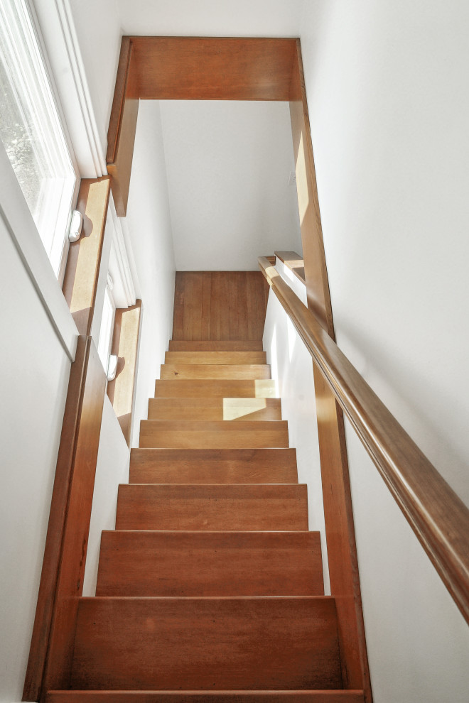 This is an example of a small traditional wood straight wood railing staircase in Portland with wood risers.