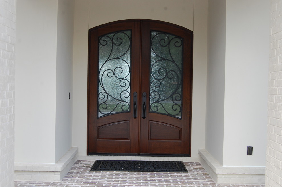 Front door - large rustic brick floor front door idea in Miami with white walls and a dark wood front door