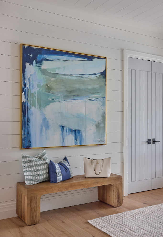 2 Chicks Happy Family Home - A custom entry / foyer moment in a Ponte Vedra Beach new build by 2 Chicks Design Co. A large-scale abstract painting in coastal blues and greens anchors a reclaimed wood bench against crisp shiplap — a quiet, collected design vignette layered into the everyday flow of the home. Beautiful closet doors painted in an accent color provide a custom and elevated detail. 
Tags: Transitional, Beach Style, Hallway, Shiplap, Abstract Art, Wood Bench, Coastal Decor