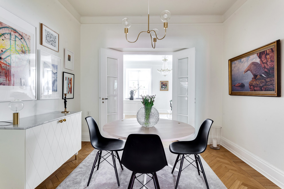 Photo of a mid-sized scandinavian separate dining room in Stockholm with white walls, medium hardwood floors and no fireplace.
