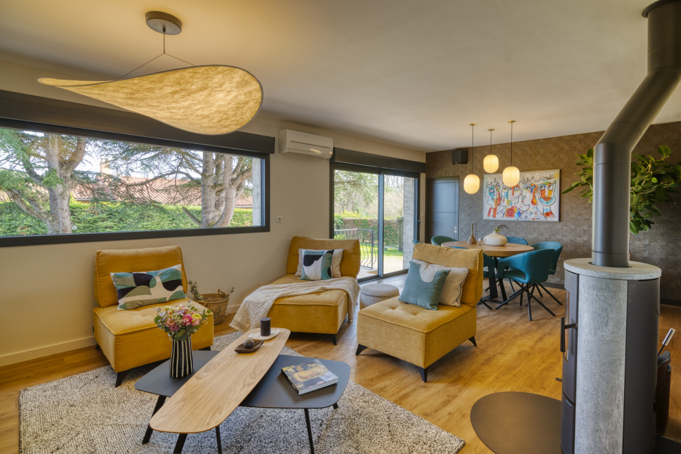 This is an example of a medium sized contemporary open plan living room in Toulouse with beige walls, light hardwood flooring, a wood burning stove, beige floors and wallpapered walls.