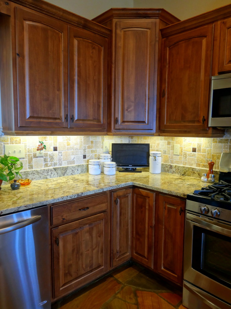 Inspiration for a mid-sized rustic l-shaped slate floor open concept kitchen remodel in Charlotte with a farmhouse sink, raised-panel cabinets, dark wood cabinets, granite countertops, multicolored backsplash, ceramic backsplash, stainless steel appliances and a peninsula