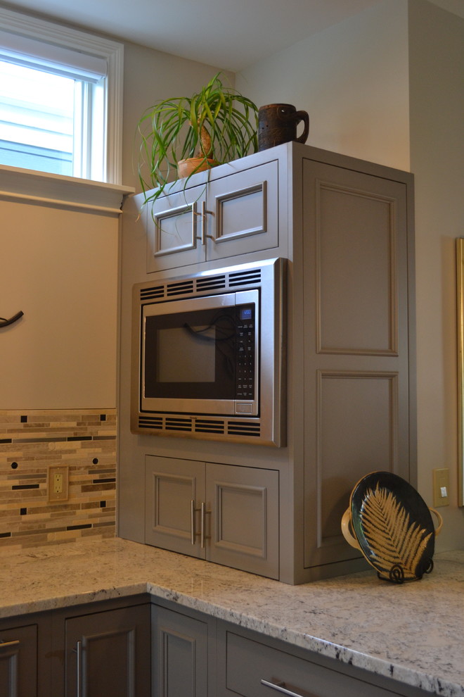 Inspiration for a large transitional l-shaped medium tone wood floor open concept kitchen remodel in Cincinnati with an undermount sink, gray cabinets, granite countertops, multicolored backsplash, mosaic tile backsplash, stainless steel appliances, an island and beaded inset cabinets