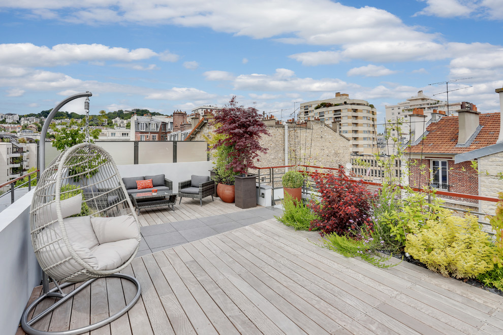 This is an example of a large contemporary rooftop and rooftop deck in Paris with no cover, a container garden and wood railing.