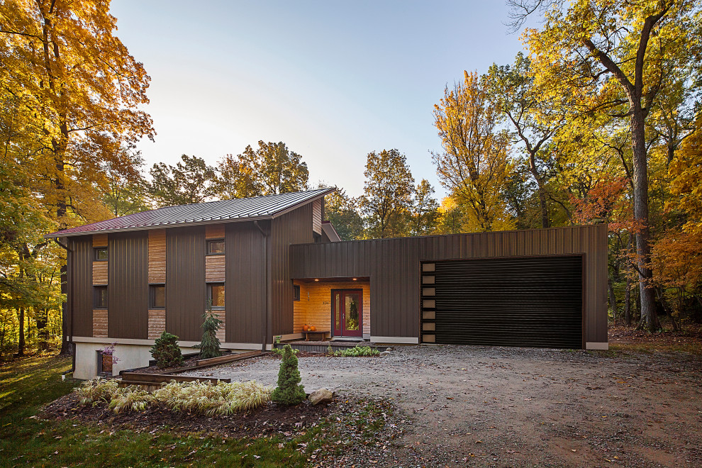 Стильный дизайн: двухэтажный, коричневый частный загородный дом среднего размера в стиле модернизм с комбинированной облицовкой, односкатной крышей, металлической крышей и красной крышей - последний тренд