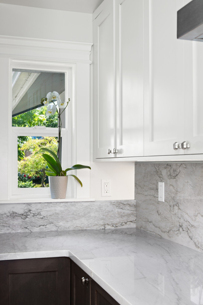 Example of a large transitional u-shaped laminate floor, brown floor and vaulted ceiling open concept kitchen design in Seattle with an undermount sink, shaker cabinets, dark wood cabinets, quartzite countertops, white backsplash, stone slab backsplash, stainless steel appliances, two islands and white countertops