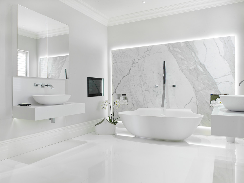 Design ideas for a large contemporary master bathroom in London with a freestanding tub, white tile, marble, white walls, porcelain floors, a vessel sink, solid surface benchtops, white floor and white benchtops.