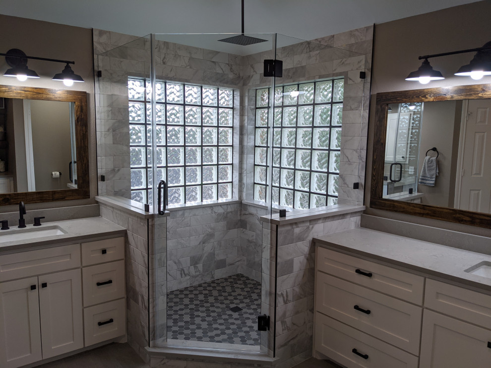 This is an example of a transitional master bathroom in Houston with shaker cabinets, white cabinets, a corner shower, a one-piece toilet, white tile, porcelain floors, an undermount sink, engineered quartz benchtops, a hinged shower door, grey benchtops, a shower seat, a double vanity and a built-in vanity.