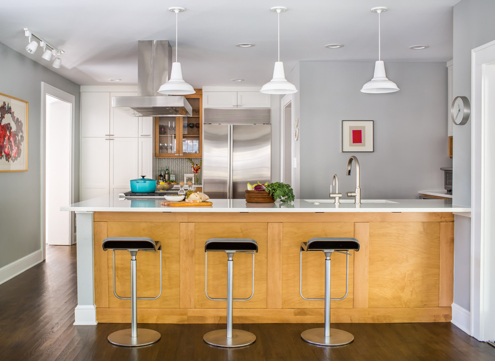 Example of a transitional u-shaped dark wood floor and brown floor kitchen design in Atlanta with an undermount sink, shaker cabinets, medium tone wood cabinets, gray backsplash, stainless steel appliances and a peninsula
