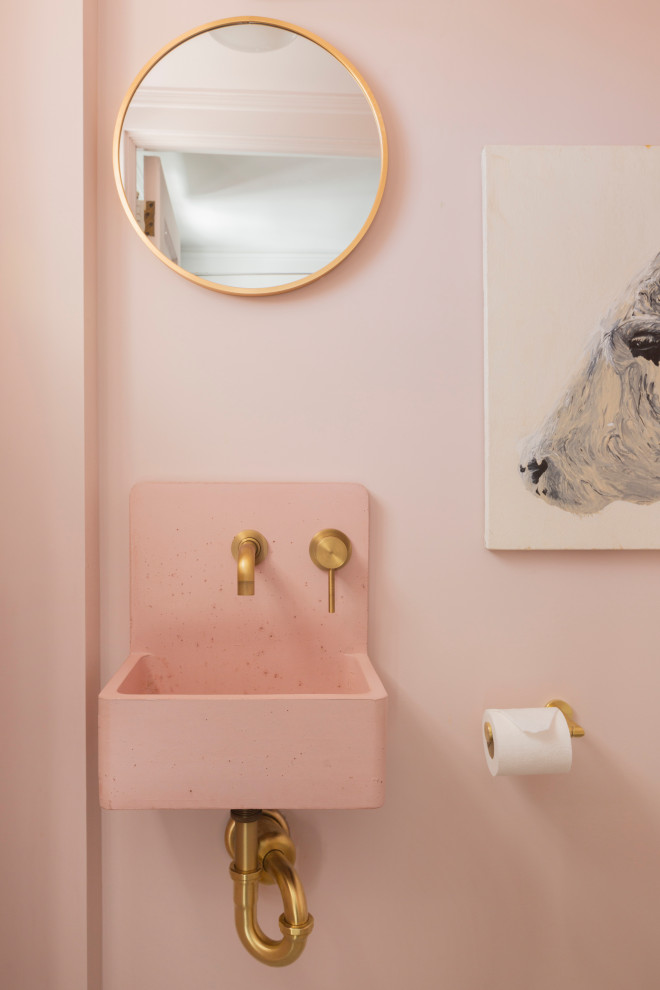 На фото: маленький туалет в стиле неоклассика (современная классика) с раздельным унитазом, розовыми стенами, полом из цементной плитки, подвесной раковиной, черным полом и розовой столешницей для на участке и в саду