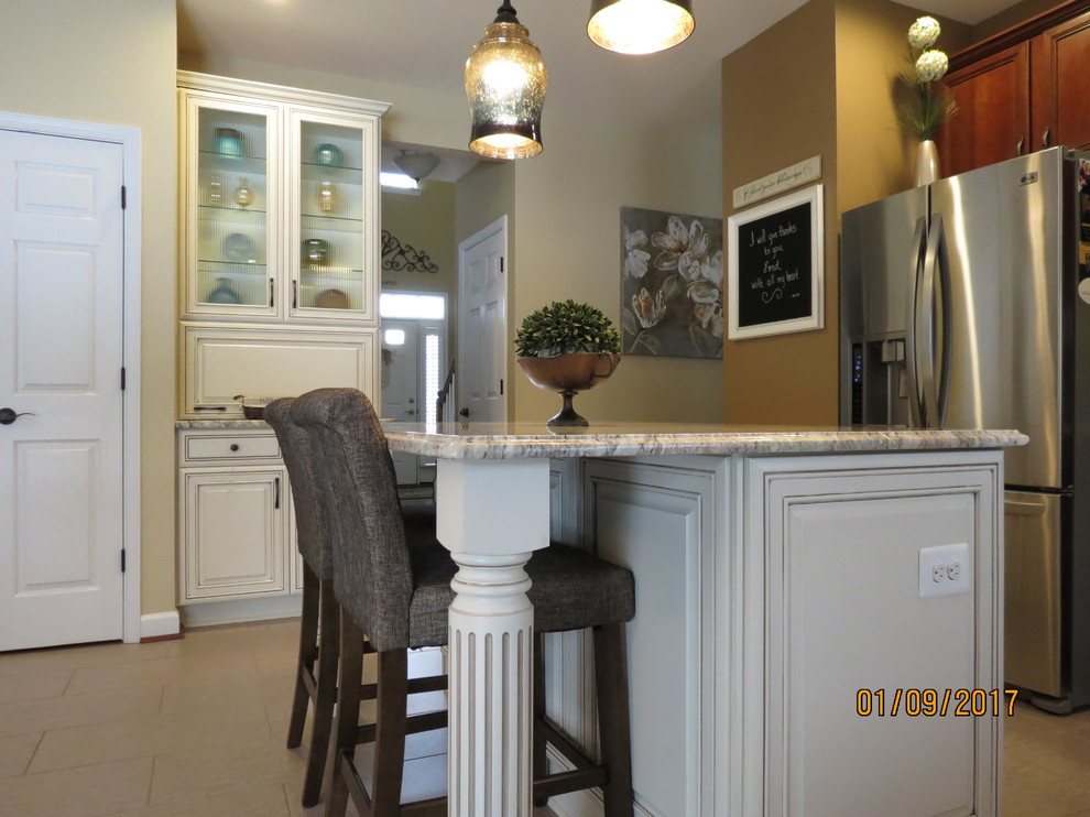 Mid-sized transitional l-shaped ceramic tile eat-in kitchen photo with an undermount sink, raised-panel cabinets, distressed cabinets, granite countertops, white backsplash, porcelain backsplash, stainless steel appliances and an island