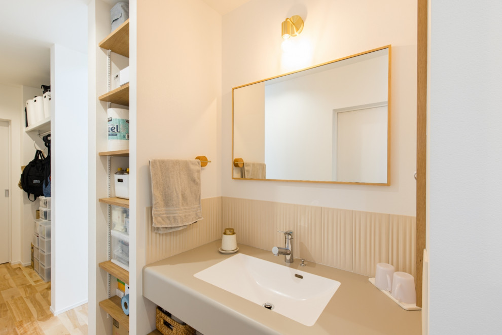 Photo of a contemporary powder room in Other with beige cabinets, white tile, beige benchtops, a built-in vanity, white walls, medium hardwood floors, an undermount sink, solid surface benchtops, white floor, wallpaper and wallpaper.