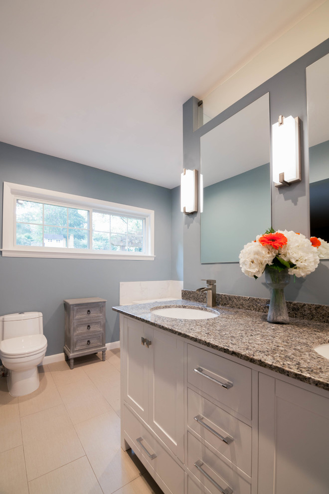 This is an example of a large transitional master bathroom in Atlanta with shaker cabinets, white cabinets, a drop-in tub, a curbless shower, a one-piece toilet, white tile, ceramic tile, blue walls, ceramic floors, an undermount sink, granite benchtops, beige floor and an open shower.