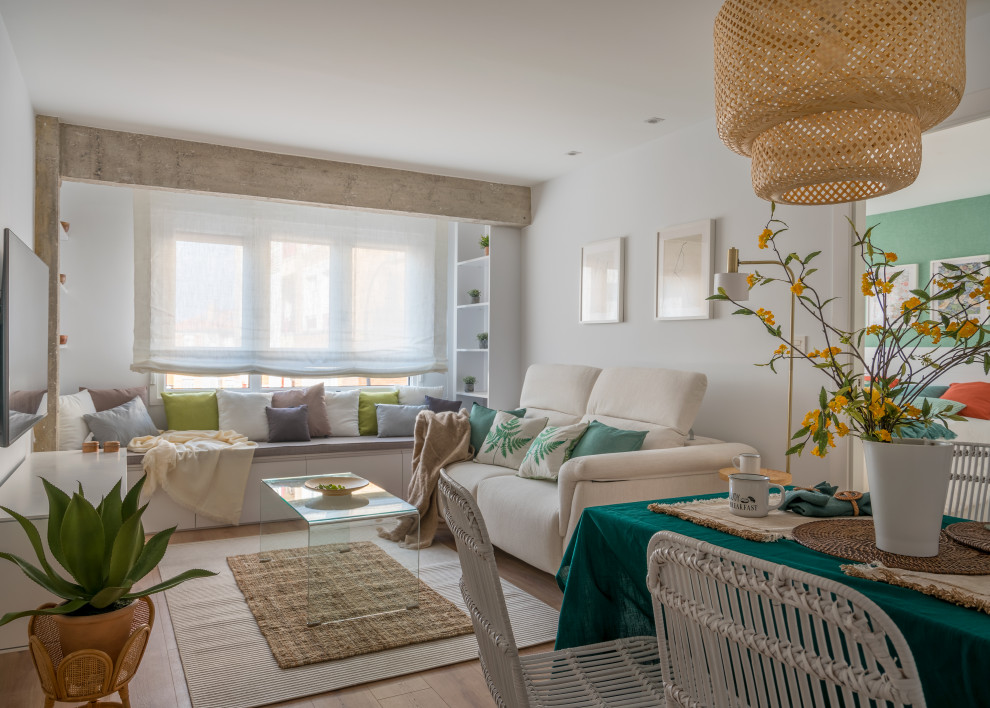 Idee per un piccolo soggiorno mediterraneo con pareti bianche, pavimento in laminato, TV a parete e pavimento marrone
