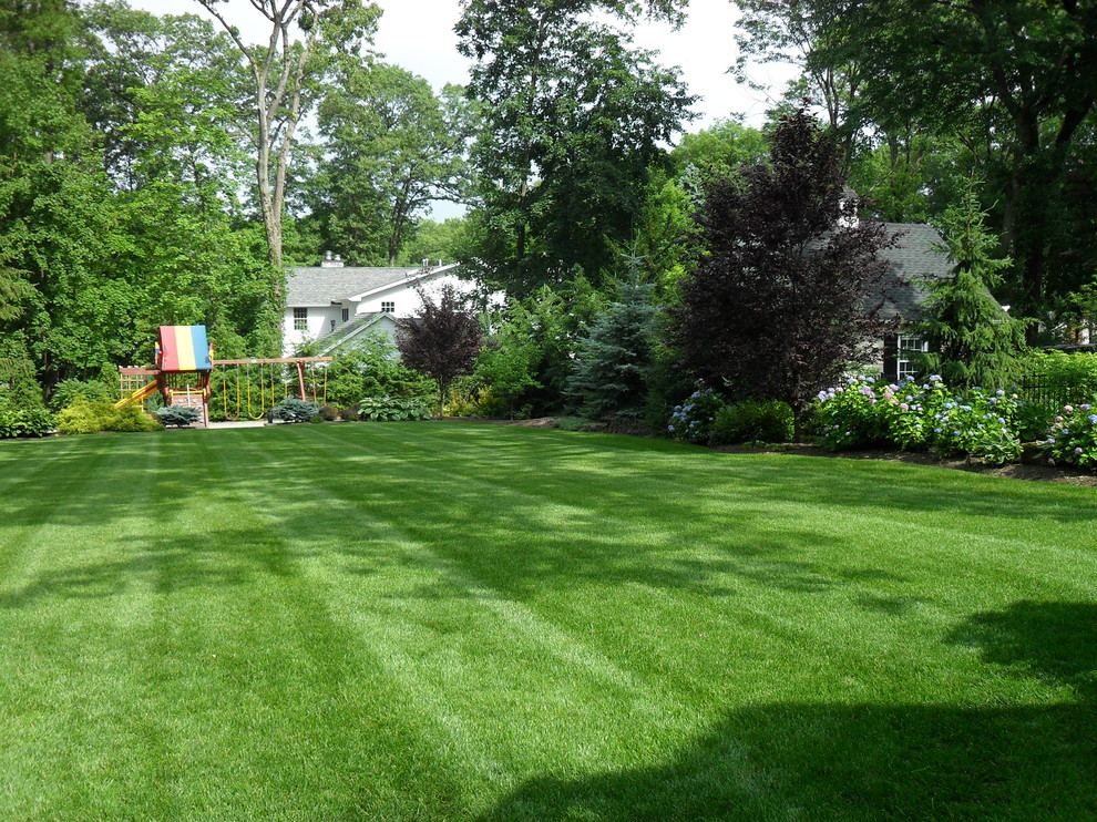 Design ideas for a large traditional backyard garden in New York with with outdoor playset and mulch.