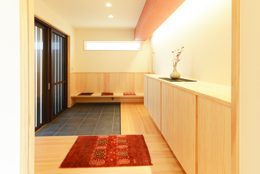 Inspiration for a large asian entry hall in Other with white walls, a black front door and black floor.
