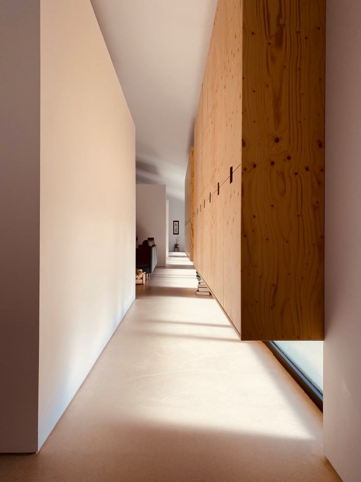 Idee per un ingresso o corridoio industriale di medie dimensioni con pareti bianche, pavimento in cemento e pavimento grigio