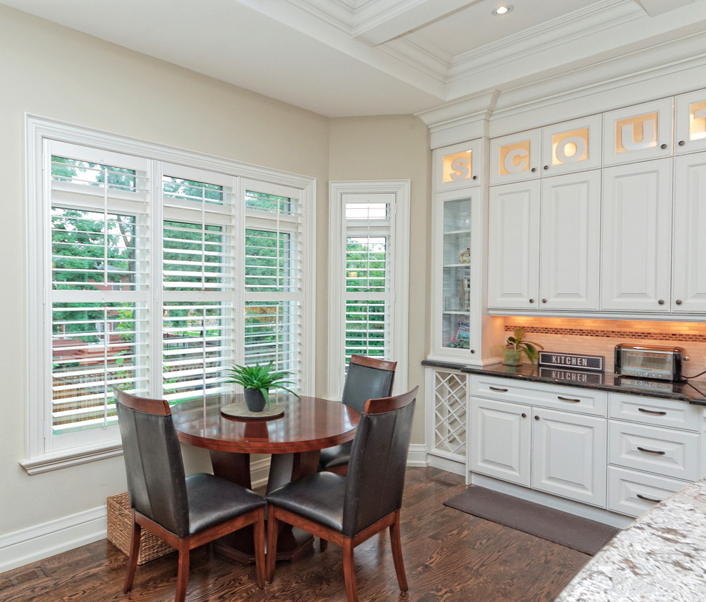 Inspiration for a large transitional single-wall dark wood floor and brown floor kitchen remodel in Toronto with a double-bowl sink, raised-panel cabinets, white cabinets, granite countertops, beige backsplash, stainless steel appliances and an island