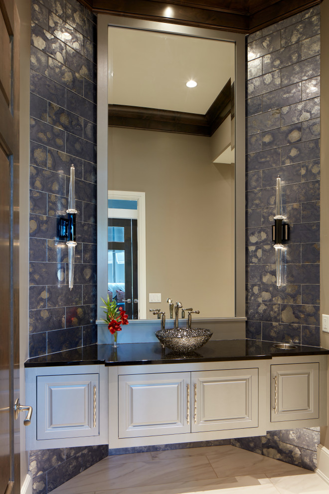 Inspiration for a mid-sized transitional powder room in Omaha with raised-panel cabinets, white cabinets, blue tile, glass tile, porcelain floors, a pedestal sink, granite benchtops, white floor and black benchtops.