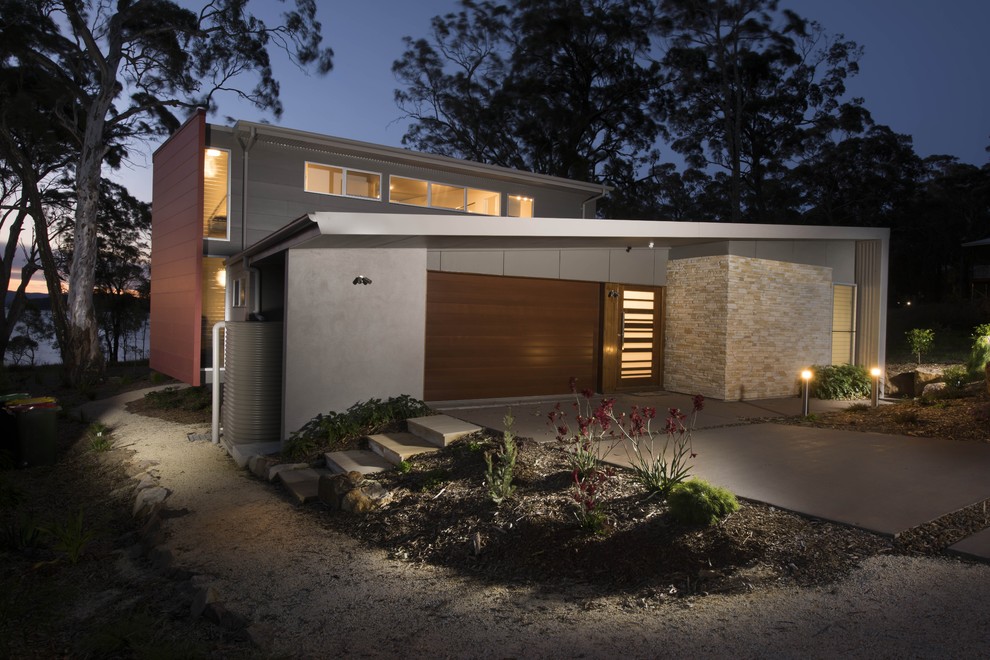 Inspiration for a mid-sized contemporary two-storey exterior in Newcastle - Maitland with stone veneer and a flat roof.