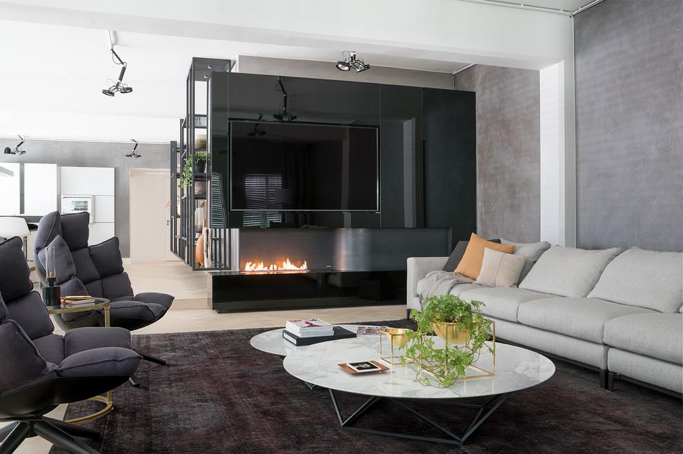 This is an example of a large contemporary living room in Amsterdam with a corner fireplace and a metal fireplace surround.