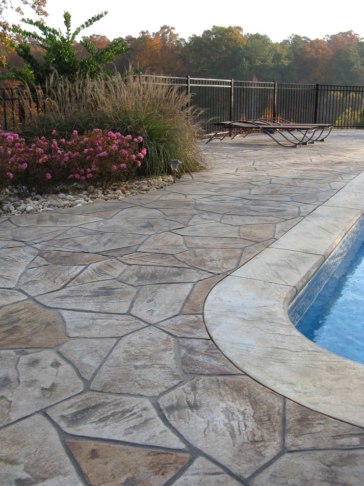 Design ideas for a mid-sized traditional backyard custom-shaped natural pool in Atlanta with stamped concrete.
