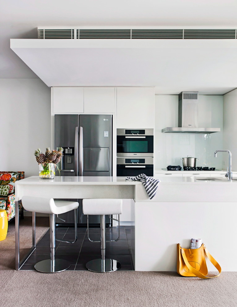 Design ideas for a contemporary kitchen in Melbourne with an undermount sink, flat-panel cabinets, white cabinets, glass sheet splashback, stainless steel appliances and a peninsula.