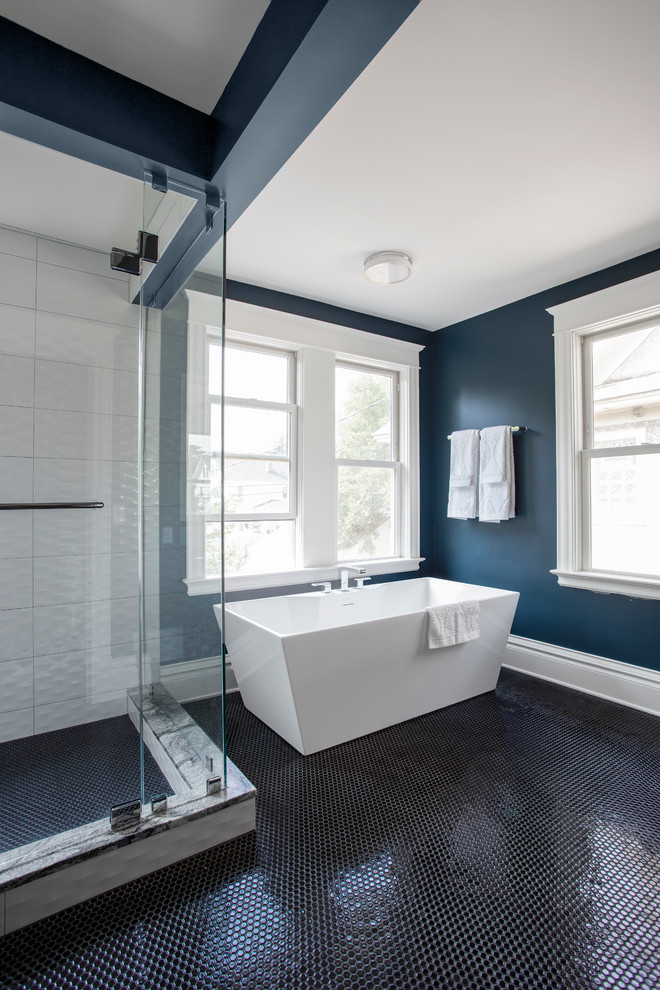 Expansive traditional master bathroom in Minneapolis with furniture-like cabinets, black cabinets, a freestanding tub, a corner shower, a one-piece toilet, white tile, ceramic tile, blue walls, mosaic tile floors, an undermount sink, granite benchtops, black floor, a hinged shower door and white benchtops.