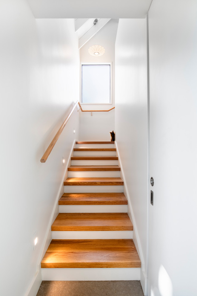 Inspiration pour un escalier minimaliste en L avec des marches en bois et un garde-corps en bois.