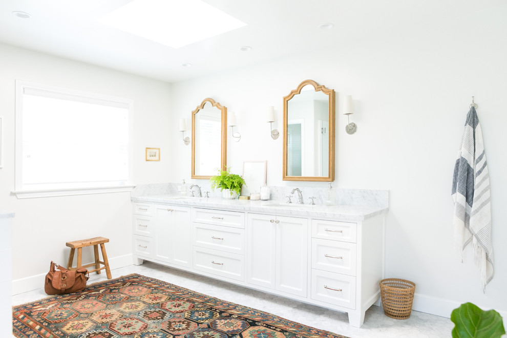 This is an example of a beach style master bathroom in Los Angeles with shaker cabinets, white cabinets, white walls, marble floors, an undermount sink and marble benchtops.