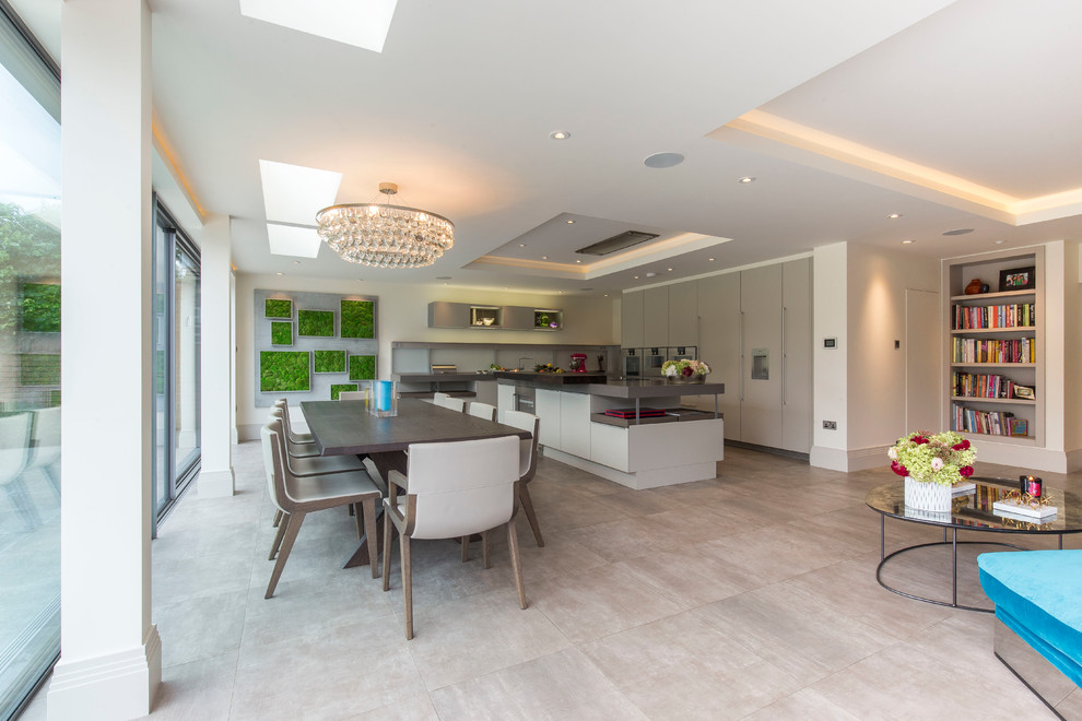 Large contemporary kitchen in London with flat-panel cabinets, grey cabinets, panelled appliances, porcelain floors and with island.
