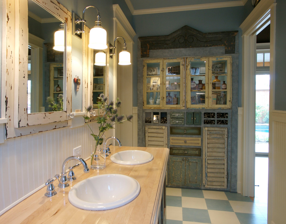 Photo of a mid-sized traditional master bathroom in Dallas with a drop-in sink, shaker cabinets, blue cabinets, wood benchtops, blue tile, ceramic tile, blue walls and ceramic floors.