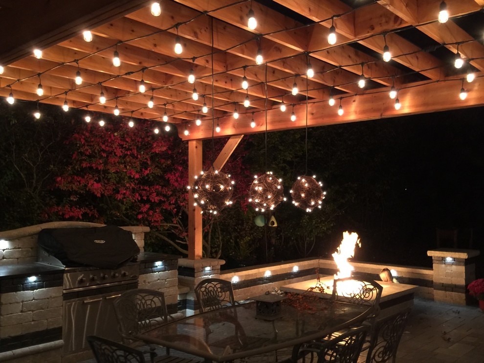 Large transitional backyard stone patio kitchen photo in Chicago with a pergola