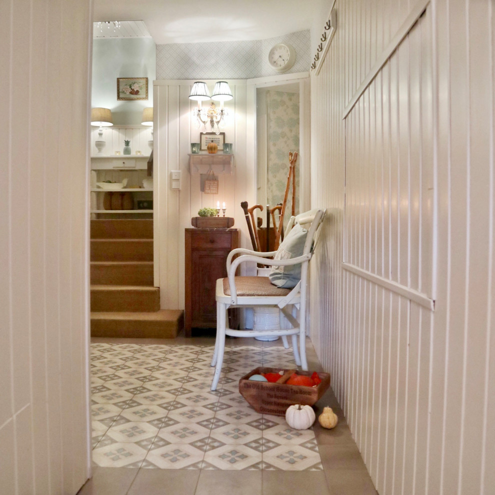 Design ideas for a mid-sized country hallway with white walls, porcelain floors, multi-coloured floor, wallpaper and panelled walls.