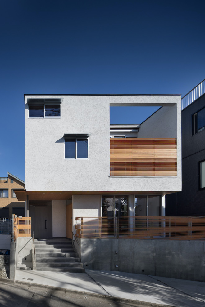 This is an example of a large and white modern two floor render semi-detached house in Tokyo with a lean-to roof, a metal roof and a grey roof.