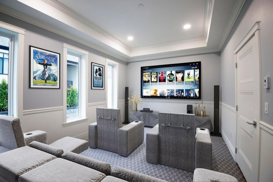 Ejemplo de cine en casa cerrado minimalista de tamaño medio con paredes grises, moqueta, televisor colgado en la pared y suelo gris