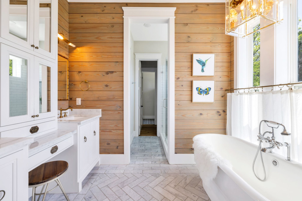 Design ideas for a nautical bathroom in Houston with recessed-panel cabinets, white cabinets, a freestanding bath, brown walls, marble flooring, a submerged sink, white floors, white worktops, double sinks, a built in vanity unit and wood walls.