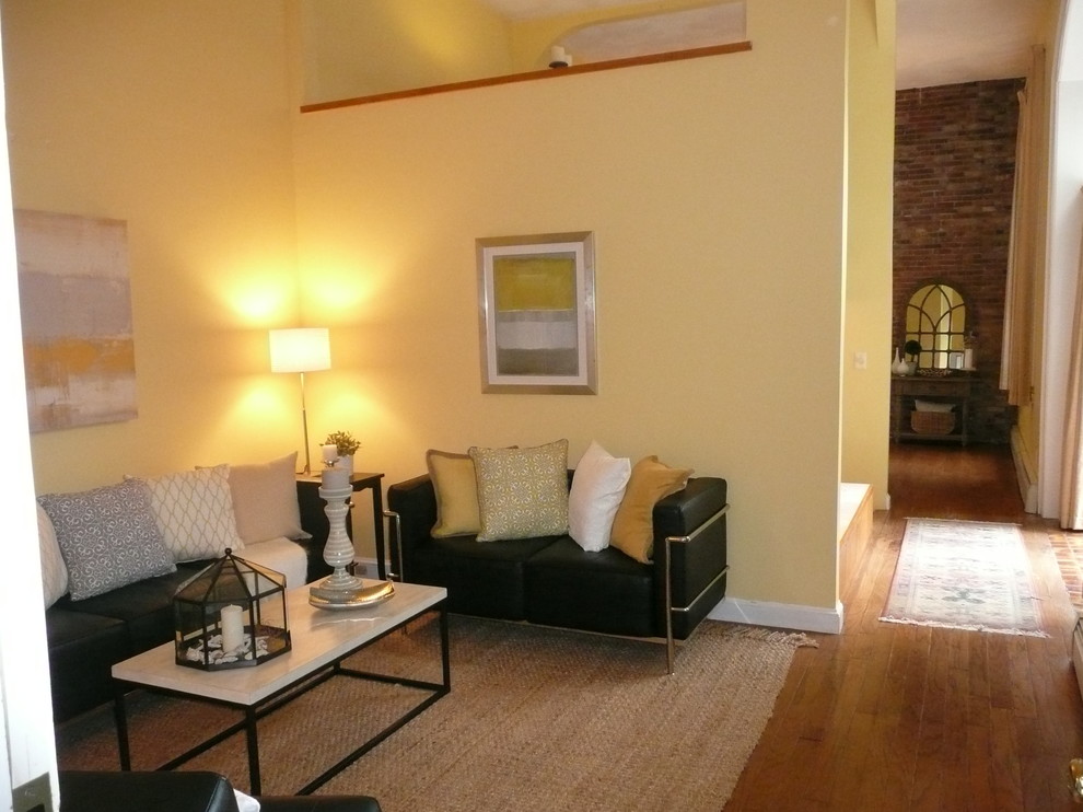 Example of a small eclectic medium tone wood floor hallway design in Boston with yellow walls