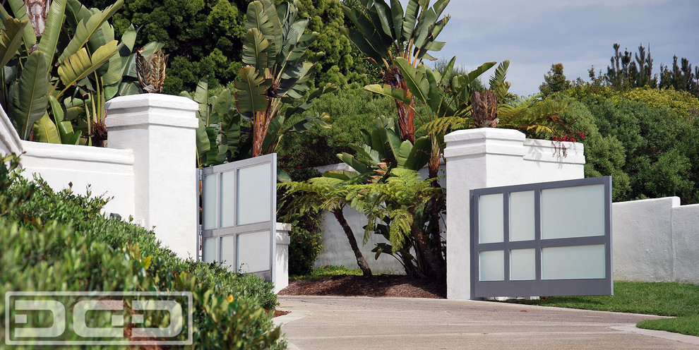 This is an example of a large modern partial sun front yard concrete paver driveway in Orange County.